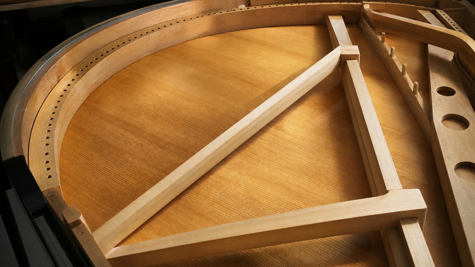 Table d'harmonie en épicéa clair d'un piano à queue vue depuis l'intérieur de la caisse